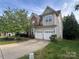 Spacious two-story home with a two-car garage, mature trees, and a well-maintained lawn at 715 Larimer Ln, Charlotte, NC 28262
