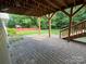 Covered patio with stone pavers, wooden support beams, and access to the backyard at 715 Larimer Ln, Charlotte, NC 28262