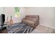 Neutral bedroom, window with outside view and reclining sofa on patterned rug at 725 Pointe Andrews Dr, Concord, NC 28025