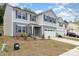 Charming two-story home with a manicured lawn and two-car garage, situated on a sunny street at 725 Pointe Andrews Dr, Concord, NC 28025