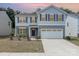 Charming two-story home featuring a two car garage, welcoming entrance and manicured landscaping at 725 Pointe Andrews Dr, Concord, NC 28025