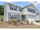 Charming two-story home with a manicured lawn, two-car garage, and inviting covered entrance at 725 Pointe Andrews Dr, Concord, NC 28025