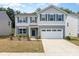 Charming two-story home featuring a two car garage, welcoming entrance and manicured landscaping at 725 Pointe Andrews Dr, Concord, NC 28025