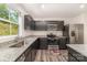 Modern kitchen featuring granite countertops, stainless steel appliances, and gray cabinets at 725 Pointe Andrews Dr, Concord, NC 28025