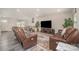 Bright living room featuring hardwood floors, modern furniture, and a large screen television at 725 Pointe Andrews Dr, Concord, NC 28025