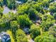 An aerial view of a beautiful home with lush, mature trees and a scenic lake nearby in a serene neighborhood at 8017 Nathanael Greene Ln, Charlotte, NC 28227