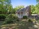 The backyard has a white deck with dining set surrounded by large bushes and mature trees at 8017 Nathanael Greene Ln, Charlotte, NC 28227
