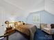 A nicely lit bedroom, contains a full size bed, window, and side chair at 8017 Nathanael Greene Ln, Charlotte, NC 28227