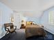 A nicely lit bedroom, contains a full size bed, and a patterned side chair at 8017 Nathanael Greene Ln, Charlotte, NC 28227
