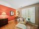 Cozy sitting room with hardwood floors, shuttered windows, a comfortable armchair, and elegant decor for a peaceful retreat at 8017 Nathanael Greene Ln, Charlotte, NC 28227