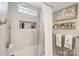 Renovated bathroom features sleek tile, a shower with a rain showerhead and a built-in niche at 8056 Stevens Mill Rd, Matthews, NC 28104