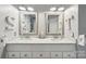 Bright bathroom with a double sink vanity, granite countertop, framed mirrors and modern hardware at 8056 Stevens Mill Rd, Matthews, NC 28104