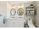 Bright bathroom featuring double vanity, decorative mirrors, a toilet, and tasteful decor at 8056 Stevens Mill Rd, Matthews, NC 28104