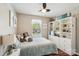 Comfortable bedroom with a large bed, window, wood-look flooring, a ceiling fan, and built-in shelving at 8056 Stevens Mill Rd, Matthews, NC 28104