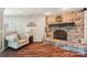 Cozy living room featuring a stone fireplace, wood flooring, and comfortable seating area for relaxation at 8056 Stevens Mill Rd, Matthews, NC 28104
