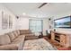 Living room with comfortable sofa, media center, television, an area rug and a bright window at 8056 Stevens Mill Rd, Matthews, NC 28104