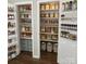 Organized pantry with shelves and door racks, filled with labeled jars and containers for efficient food storage at 8056 Stevens Mill Rd, Matthews, NC 28104
