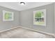Serene bedroom with neutral walls and carpet, brightened by two large, light-filled windows at 8303 Hemby Wood Dr, Indian Trail, NC 28079