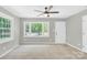 Inviting living room with a ceiling fan, neutral walls, and a bright, airy ambiance from the large windows at 8303 Hemby Wood Dr, Indian Trail, NC 28079