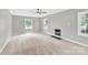 Expansive living room featuring soft carpeting, a ceiling fan, a fireplace, and an abundance of natural light at 8303 Hemby Wood Dr, Indian Trail, NC 28079