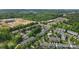 An aerial view of a neighborhood with surrounding businesses and lush trees in a suburban setting at 9204 Washam Potts Rd, Cornelius, NC 28031