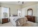 A cozy main bedroom featuring neutral tones, a four-poster bed, and a ceiling fan at 9204 Washam Potts Rd, Cornelius, NC 28031