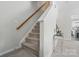 Carpeted staircase with a light wood railing leading to the upper level at 9204 Washam Potts Rd, Cornelius, NC 28031