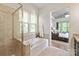 Bright bathroom featuring a shower, large tub, and view into the bedroom at 938 Rock Forest Way, Fort Mill, SC 29707