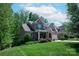 Beautiful two-story brick home with lush green lawn and landscaping beneath a cloudy blue sky at 938 Rock Forest Way, Fort Mill, SC 29707