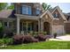 Close-up of a brick home featuring a stone archway, well-manicured landscaping, and a charming front porch at 938 Rock Forest Way, Fort Mill, SC 29707