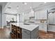 Bright kitchen with white cabinets, a large center island with bar seating, and stainless steel appliances at 938 Rock Forest Way, Fort Mill, SC 29707