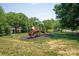 Community playground with a slide set on grass surrounded by lush trees and landscaping at 938 Rock Forest Way, Fort Mill, SC 29707
