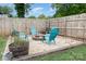 Outdoor fire pit area with Adirondack chairs, a wooden fence and mature landscaping at 1005 N Main St, Mount Holly, NC 28120