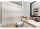 Bathroom showcasing a shower, toilet, and vanity with sink and decorative mirror at 1005 N Main St, Mount Holly, NC 28120