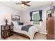 Comfortable bedroom featuring a cozy bed, wood floors, ceiling fan and natural light from the window at 1005 N Main St, Mount Holly, NC 28120