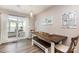 Dining area with a rustic table and bench, sliding doors to sunroom, and natural light at 1005 N Main St, Mount Holly, NC 28120