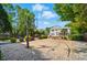 Spacious backyard with a basketball court, stone patio, and lush landscaping, perfect for outdoor activities at 10223 Willingham Rd, Huntersville, NC 28078