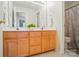 Bathroom featuring a double vanity with wood cabinets, a large mirror, and a shower with patterned curtains at 10223 Willingham Rd, Huntersville, NC 28078