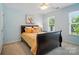 Cozy bedroom with a dark wood sleigh bed, bright yellow bedding, and natural light from two windows at 10223 Willingham Rd, Huntersville, NC 28078