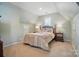 Charming bedroom with sloped ceilings, two bedside tables with lamps, and soft, inviting decor at 10223 Willingham Rd, Huntersville, NC 28078