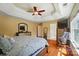 Large main bedroom with tray ceilings, hardwood floors, and rocking chair at 10223 Willingham Rd, Huntersville, NC 28078