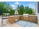 Outdoor kitchen featuring a stone surround, granite countertops, and stainless steel grill at 10223 Willingham Rd, Huntersville, NC 28078