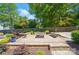 Stone patio with a modern fire pit and built-in seating, ideal for entertaining or relaxing outdoors at 10223 Willingham Rd, Huntersville, NC 28078