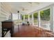 Covered porch with wood floors, white columns, and a view of the backyard and surrounding greenery at 10223 Willingham Rd, Huntersville, NC 28078