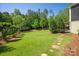 Lush backyard with a well-manicured lawn, mature trees, and stepping stones leading to a relaxing outdoor space at 1148 Wessington Manor Ln, Fort Mill, SC 29715