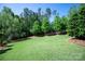 Expansive backyard with lush green lawn, mature trees, and well-maintained landscaping for outdoor enjoyment at 1148 Wessington Manor Ln, Fort Mill, SC 29715