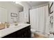 Clean bathroom featuring a shower with a white shower curtain and a vanity with a white countertop and black cabinets at 1148 Wessington Manor Ln, Fort Mill, SC 29715