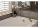 Close up of soaking tub with beautiful faucet and a decorative orchid near the window at 1148 Wessington Manor Ln, Fort Mill, SC 29715