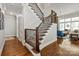 Hardwood staircase with detailed wrought iron spindles leads to a living room with lots of natural light at 1148 Wessington Manor Ln, Fort Mill, SC 29715