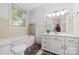Clean, bright bathroom with white fixtures, a tub, and a large window for natural light at 116 N Mulberry St, Statesville, NC 28677